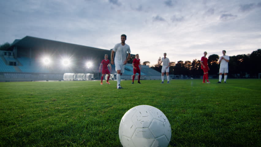 Professional Soccer Player Outruns Members of Opposing Team and Kicks Ball and Scores Goal. His Team Celebrates Victory. Cinematic Slow Motion. Royalty-Free Stock Footage #1019537554