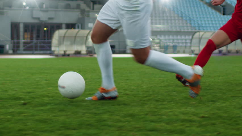 Focus on Legs of a Professional Soccer Player Leading with a Ball, Masterfully Dribbling Around His Opponents. Two Professional Football Teams Playing on Stadium. Low Angle Ground Shot. | Shutterstock HD Video #1019538169