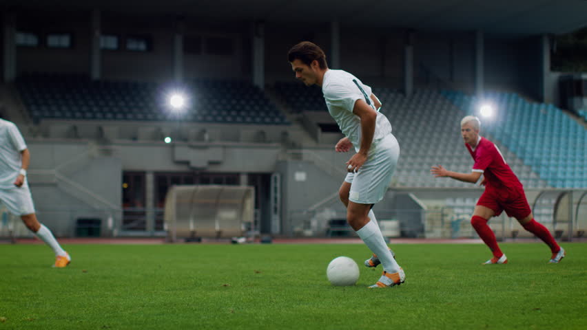 Professional Soccer Player Leading with a Ball, Masterfully Dribbling Around His Opponents. Two Professional Football Teams Playing on Stadium. Championship Tournament in Action. Energetic Play. Royalty-Free Stock Footage #1019538172