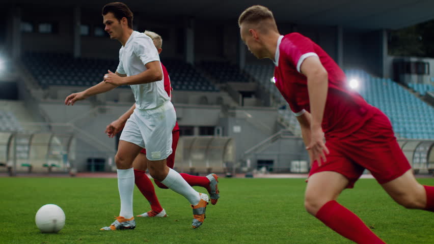 Focus on Legs of a Professional Soccer Player Leading with a Ball, Masterfully Dribbling Around His Opponents. Two Professional Football Teams Playing on Stadium. Energetic Play. | Shutterstock HD Video #1019538172