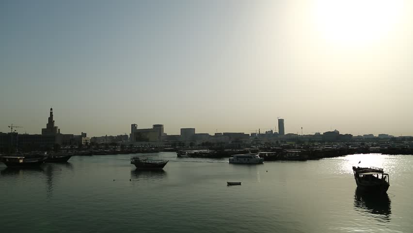 Harbour at sunset in Doha old town, Qatar, Persian Gulf, Arabian Peninsula, Middle East. Doha - capital and most populous city in Qatar. Dhow - traditional wooden Qatari boat
