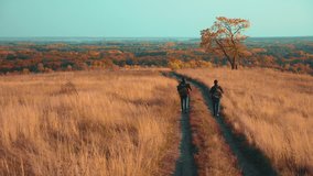 people tourists travel in nature the autumn adventure. slow motion video. two hiker outdoor with backpacks lifestyle hiking . tourist concept travel man tourism