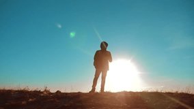 Male man worth it tourist with backpack smartphone navigation sunlight stands on top of a mountain. slow motion lifestyle video. man silhouette at sunset . hikers adventure and the go walking. travel
