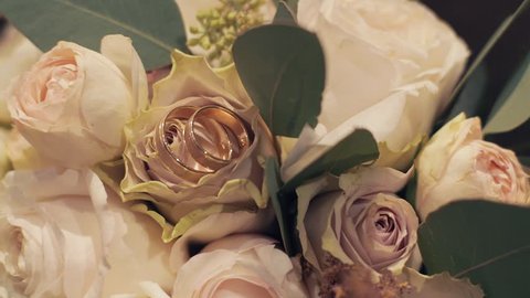 Wedding rings lie near beautiful wedding bouquet