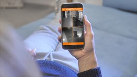 woman looking home security camera from smartphone application - Powered by Shutterstock - Get 15% off with code: PIKWIZARD15