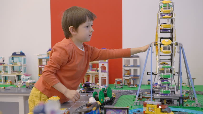 Little boy playing with lots of colorful plastic toys