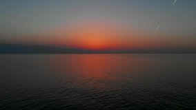 Sea sunset aerial. Beautiful red sunset sky above Black Sea, Georgia. Aerial video, 4K.  Epic sunset over sea, drone flight. 