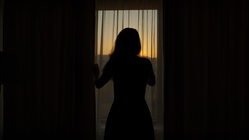 Woman close blackout curtains at early morning, want to sleep more, bedroom become completely dark. She shut left and then right sides of hanging textile over large window. Dim sun disk shine low Royalty-Free Stock Footage #1019584276