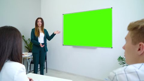 young happy teacher near with a green screen board teaching students in classroom. interactive education, practice, learning, education, knowledge concept