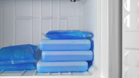 Ice packs of blue color lie in the freezer.