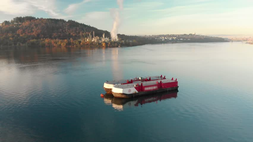 An aerial shot of a barge in Burrard Inlet with the Parkland oil refinery and downtown Vancouver in the background.