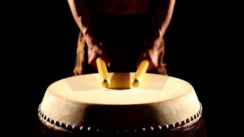 performance of Taiko , Asian male drummer is very expressive beats the rhythm drum ,Hand Close up,black background