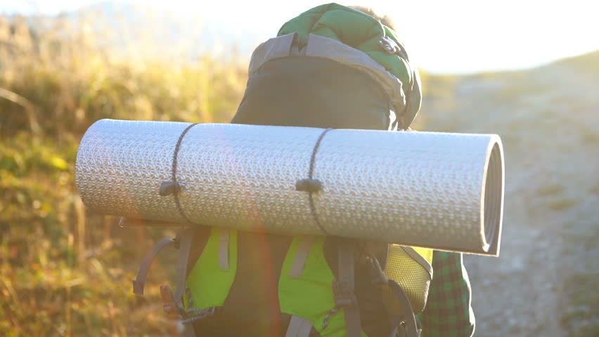 Slow-motion footage of a backpacker going up the hill