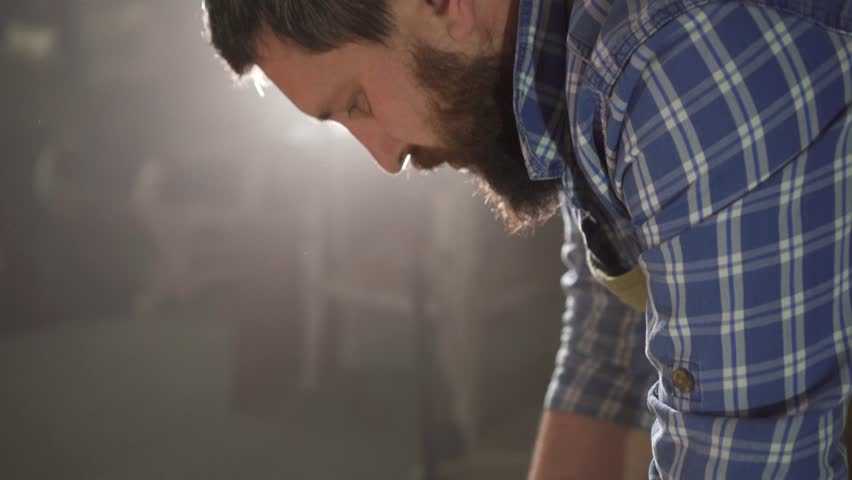 samples of colored fabric for making furniture in the hands of a bearded man in an authentic workshop