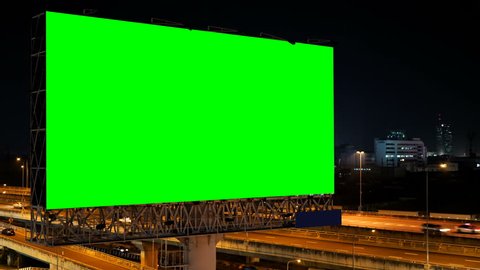 Green screen of advertising billboard on expressway during the twilight with city background in Bangkok, Thailand.