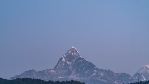 Snow Peak of Machapuchare Mountain also called Fishtail Mountain at Sunrise in the Himalayas in Nepal. Timelapse