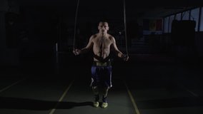Boxer trains to jump rope: Jumping rope, a professional boxing coach trains in a dark gym. - Powered by Shutterstock - Get 15% off with code: PIKWIZARD15