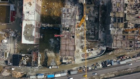 Aerial view of construction workers work on top of the building at construction site - Drone is rising up