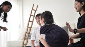 Asian family playing wooden blocks together at home.  Blocks are falling on kid head, slow motion. - Powered by Shutterstock - Get 15% off with code: PIKWIZARD15