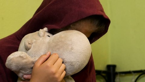 teen holds a stuffed toy because depressed