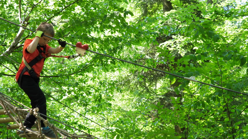 Child climbing on rape at adventure park, dare to exceed your limits, conceptual