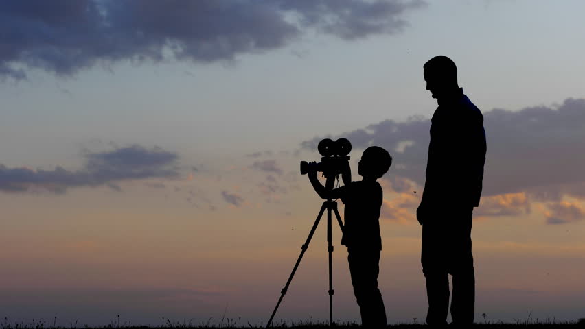 Man assisting child in taking photos and movies at sunset Royalty-Free Stock Footage #1019657089