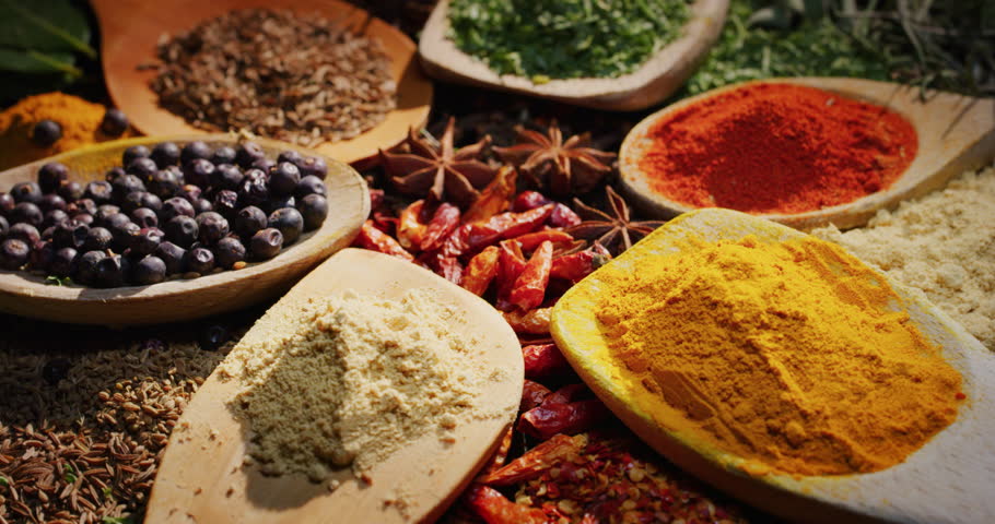 Close -up of a nice composition of spices and spoons on a turning base on bench. Concept: Food, tradition, travel
