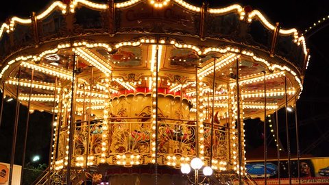 Incredible colorful flashing light of vintage carousel carnival fair merry go round circus horse ride at amusement park