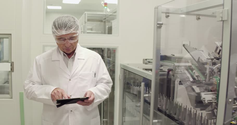 Medecine specialist using tablet while taking inventory in pharmaceutical factory. Royalty-Free Stock Footage #1019692267