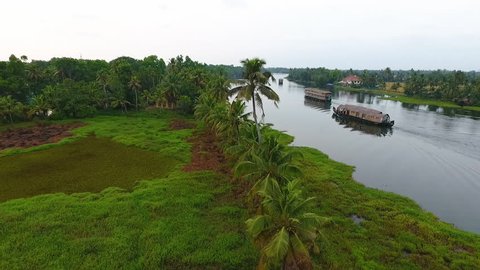 An aerial drone shot over houses on the backwaters banks in Kerala India.