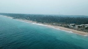 aerial footage drone flying over road coastal highway between the ocean coast and buildings tropical green forest beauty nature summer day Sri Lanka  video