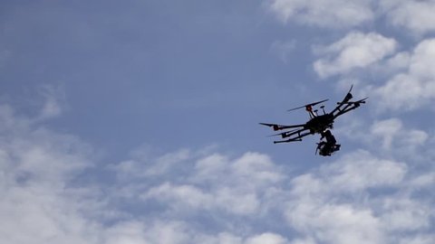 Professional drone flies in the sky while shooting with the camera. Slowmotion