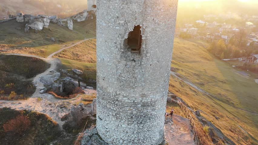 old middle-age castle ruins form white stone on sunset with polish flag