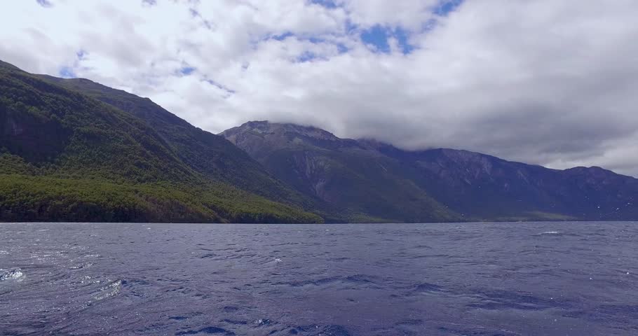 motor boat sailing on Blue Lake, with tourists sitting in front