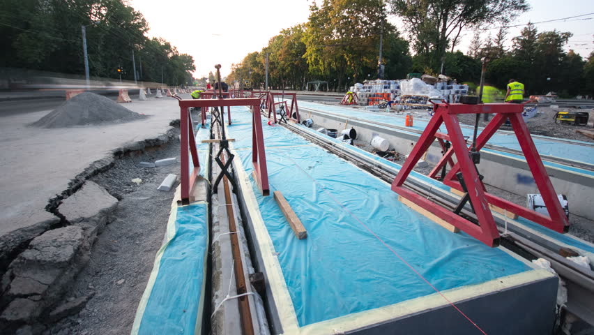 Tram rails at the stage of their installation and integration into concrete plates on the road timelapse hyperlapse. Filling by liquid resin for reduction of vibration and noice. The process of