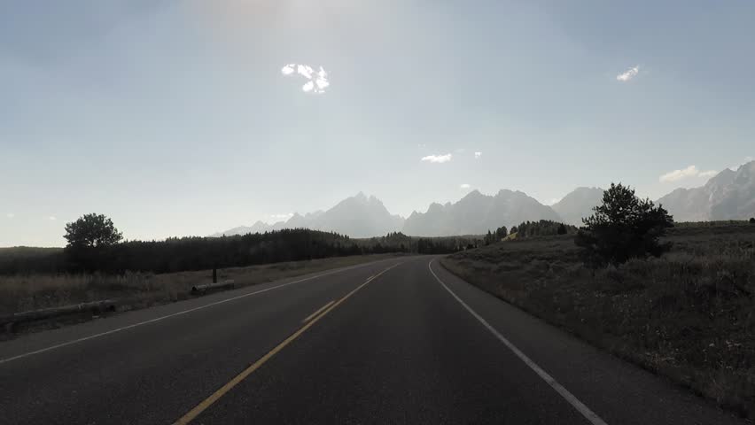 Driving a Car in Grand Teton park fast-forwarded, sunny, Point of View - Mounted 2.7k Ultra HD footage