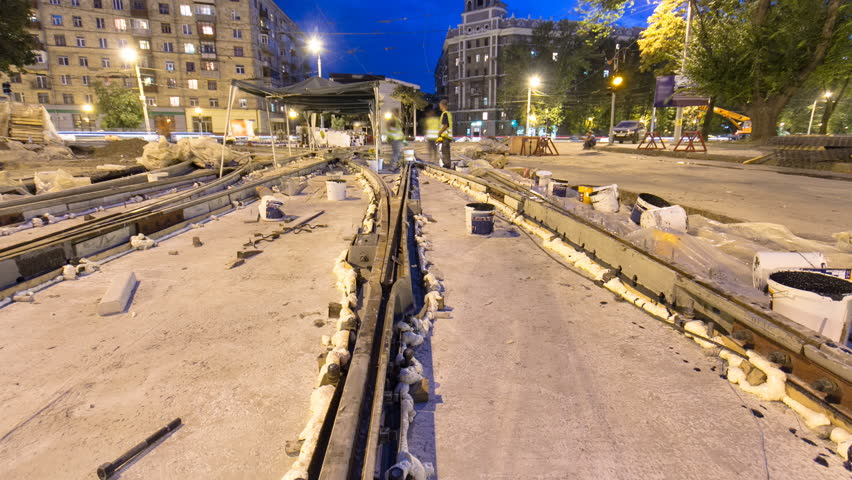 Tram rails at the final stage of their installation and integration into concrete plates on the road night timelapse hyperlapse. Filling by liquid resin for reduction of vibration and noice. The