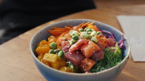 Raw Organic Ahi Tuna Poke Bowl with Rice and Veggies close-up on the table. Top view from above