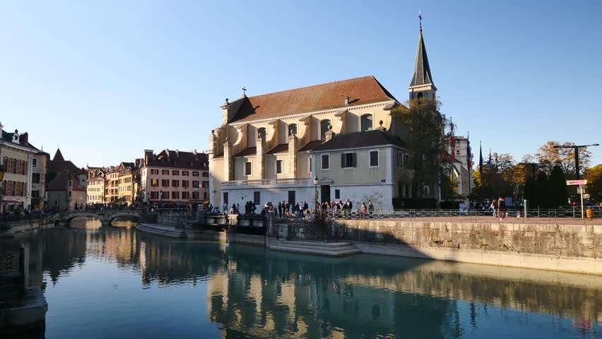 Canal of the old town of Annecy. View on the quays and a church in the background. Sunny day, blue sky.
