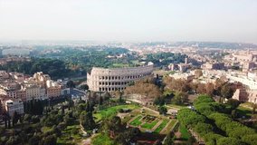 Aerial drone view video of iconic ancient Arena of Colosseum, also known as the Flavian amphitheatre in the heart of Rome next to Roman Forum, Italy