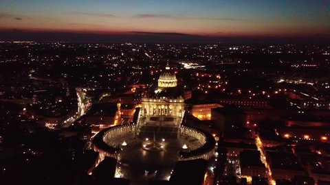 Aerial drone video of Saint Peter's square, world's largest church - Basilica of St. Peter's, Vatican at dusk, Rome, Italy