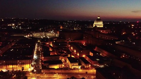 Aerial drone night video of Saint Peter's square, world's largest church - Papal Basilica of St. Peter's, Vatican - an elliptical esplanade created in the mid seventeenth century, Rome, Italy
