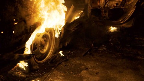 A wheel burns in a car at night, car tires burn, close-up
