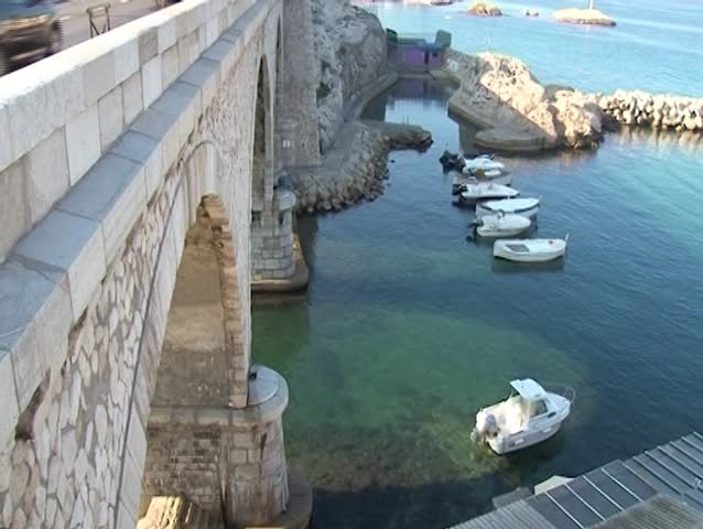the view on the small fishing boats in haven through the old arch bridge, Vallon des Auffes, Marseille