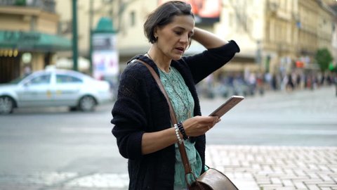 Young woman checking smartphone while waiting for someone in city