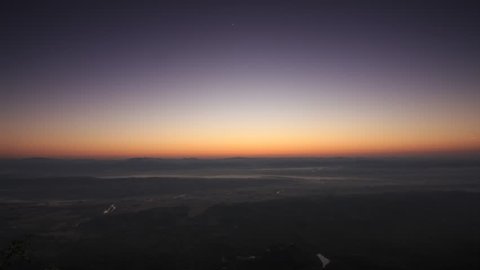 Timelape Sunrise night to day on top view of mountain sun rising from behind mountain horizon time lapse, in Lampang , Thailand.