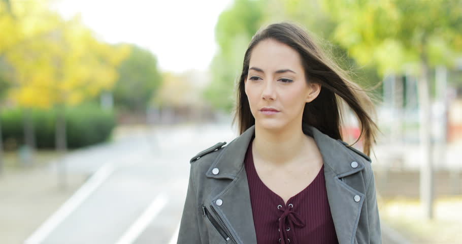Front view of a serious pensive woman walking towards camera looking at side in a park Royalty-Free Stock Footage #1019750590