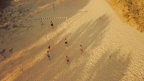 Sport Soccer players in dynamic action funny play on the sand in beach football in summer sunny day under sunlight. Aerial View, Drone 4K Video
