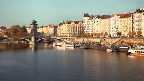 Prague, Czech Republic - August 2018: Old Town view with river, docking boats, bridge and traffic in evening light. 4K resolution