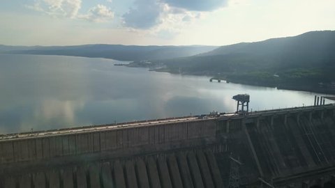 Drone shot of the hydroelectric power station with the city on the background